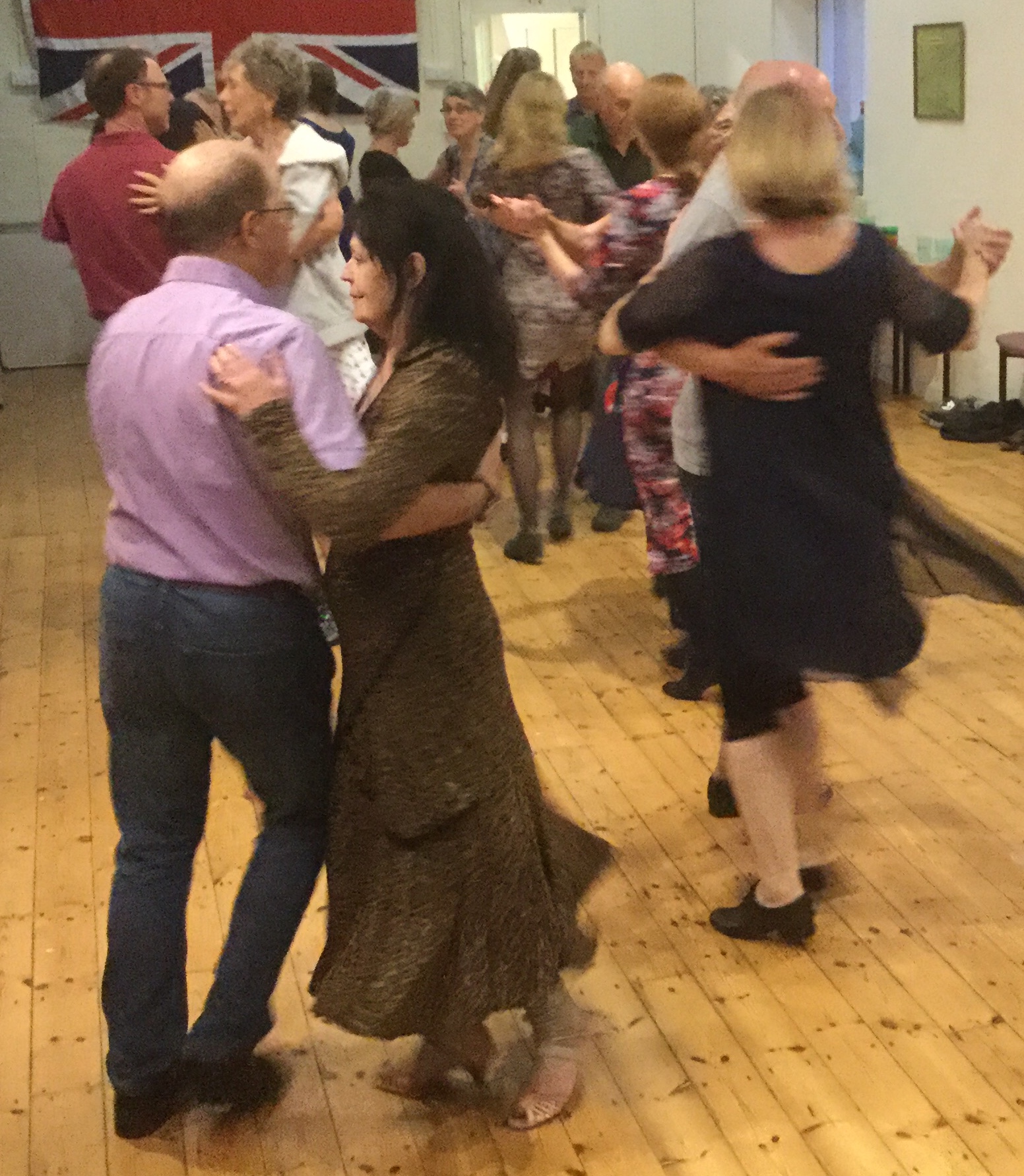 Six couples dancing in waltz hold.
